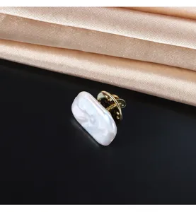 Exquisite rectangular baroque pearl brooch detail, elegant gold metal pin for chic apparel.