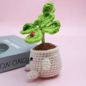 Handcrafted crochet four-leaf clover potted plant decor with cute ladybug and limbs detail.