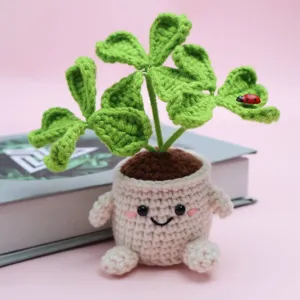 Crochet clover potted plant detail shot, showing cute handmade knit leaves and smiling pot design.