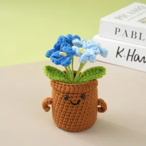 Handmade crochet potted flower detail, cute knitted desktop ornament with blue flowers.