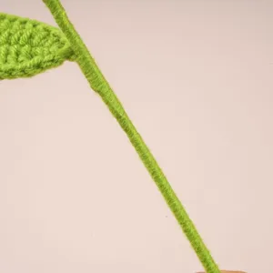 Détail de tige de plante au crochet faite main, fil vert délicat pour artisanat floral DIY.