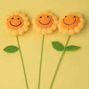 Close-up detail of cute handmade crochet smiley sunflowers with green stems, nice gift.