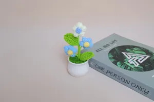 Handmade crochet flower potted plant, miniature green plant desktop decor detail view.
