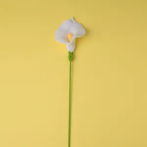 Détail de branche de fleur de lys calla blanc crocheté à la main, design de tricot en laine.