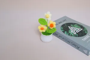 Handmade crochet potted flower detail view, cute mini green plant desk decor ornament.