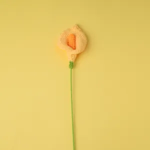 Détail de la tige de fleur de lys calla crochetée à la main, artisanat en fil jaune et orange.