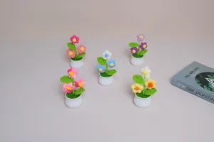 Detail view of colorful handmade crochet potted flowers, miniature woolen desktop decorations.