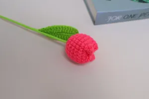 Handmade crochet wool tulip artificial flower detail view, colorful knitted floral decor.