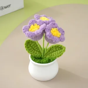 Handgearbeitete Häkelblumen im Topf, violette Strickblume als schönes Geschenk für Zuhause.