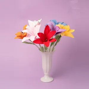 Handmade crochet lily flower closeup, multicolor yarn blooms in white vase, nice home decor.