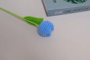 Handcrafted crochet blue tulip flower close-up detail shot, showing exquisite wool yarn texture.