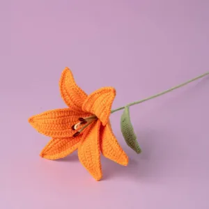 Handmade crochet orange lily flower stem, detailed knitted flower craft for home decor display.