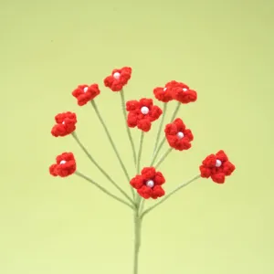 Handmade crochet red flower branch detail with pearl center, knitted botanical decor closeup.
