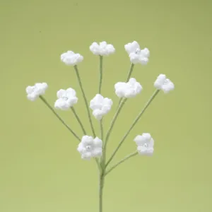 Handmade crochet white gypsophila flower detail shot, delicate knitted botanical craft.