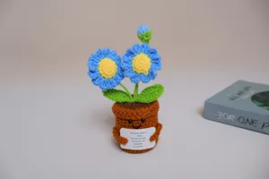 Détail de marguerite bleue en pot au crochet fait main, adorable décoration de bureau mignonne.