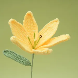 Detailed close-up view of a handmade crochet yellow lily flower with a green stem and leaf.
