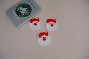 Handmade crochet Santa Claus coaster detail, cute red and white yarn cup mat craft scene.