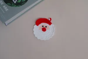 Handmade crochet Santa Claus coaster detail, cute Christmas knitted cup mat, festive decor.