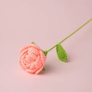 Handgefertigte gehäkelte rosa Rose einzelner Stiel Strickblume Detailansicht Geschenk Dekoration