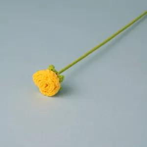 Handcrafted crochet yellow rose flower detail close-up view showing delicate green stem.