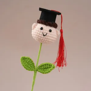 Handmade crochet graduation doll flower detail view, cute wool toy for a gift.