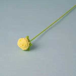 Handmade crochet yellow rose flower with green stem, detailed view of knitted craft bouquet.