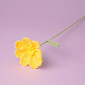 Detailed close-up of handmade yellow crochet flower stem showing intricate yarn texture.