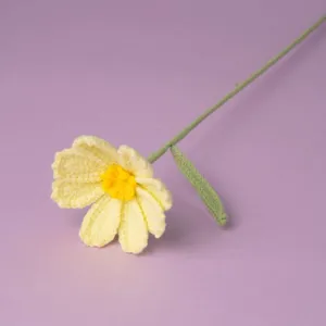 Handmade crochet flower detail, yellow daisy knit bloom with green stem for gift.