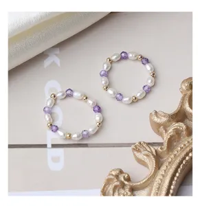 Handgemachter elastischer Perlenring aus Süßwasserperlen und Amethyst mit vergoldeten Perlen.