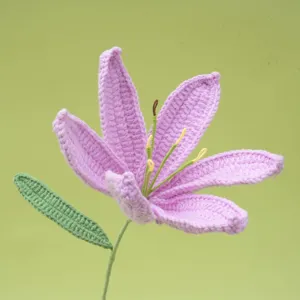 Handmade crochet pink lily flower detail view, beautiful knitted yarn floral decor piece.