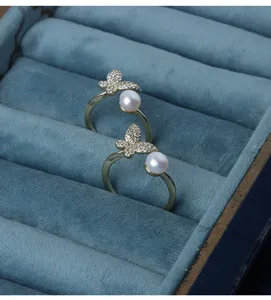 Nahaufnahme von eleganten Süßwasserperlen Schmetterling Ringen im blauen Samtkasten.
