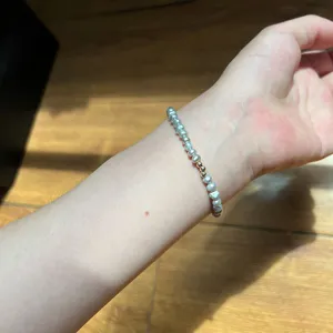 Nahaufnahme des grauen Süßwasserperlen-Armbands mit 14k vergoldeten Perlen, elastisch.