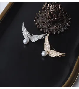 Detailaufnahme einer eleganten Engelshügel-Brosche mit glitzernden Strasssteinen und Perle.