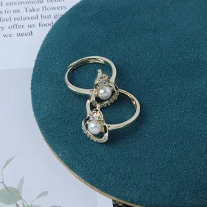 Nahaufnahme filigraner Goldperlenringe mit funkelndem Zirkonia und verstellbarem offenen Design.