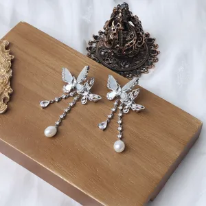 Detailaufnahme einer exquisiten Schmetterlingsbrosche mit Perle und funkelnden Zirkonen.