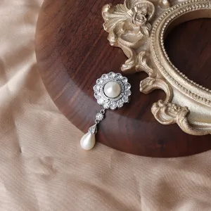 Nahaufnahme einer Luxus Strass Perlen Brosche, elegantes Blumen Design mit hängendem Perlendetail.