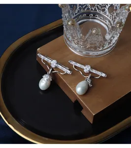 Nahaufnahme Detail der luxuriösen Kristall-Zirkon-Brosche mit hängender Süßwasserperle.