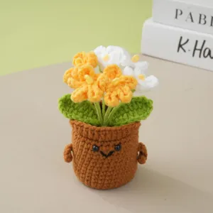 Handmade crochet potted flower detail showing cute smiling pot and yellow white blossoms.