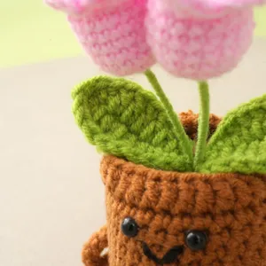 Handcrafted crochet flower potted plant detail, cute smiley flower pot design for desk decor.