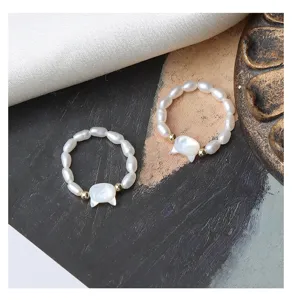 Anello in perle d'acqua dolce con ciondolo gatto in conchiglia, dettaglio di gioielli elastici.