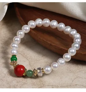 Nahaufnahme des chinesischen Perlenarmbands mit rotem Zinnober und grünen Edelsteinen.