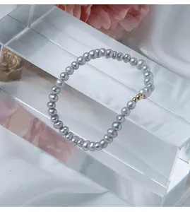Detailansicht des grauen Süßwasserperlen Armbands mit feinen 14k Gold gefüllten Perlenakzenten.