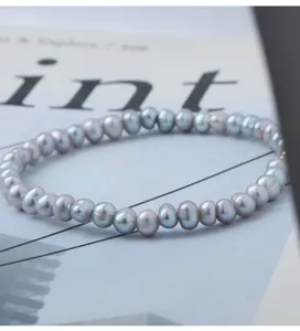 Detailansicht des grauen Süßwasserperlenarmbands mit natürlichem Glanz und elastischem Design.