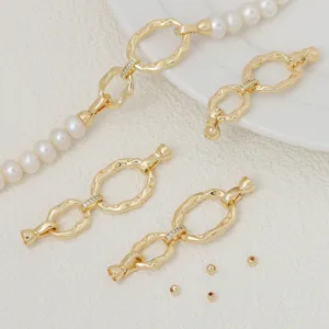 Primer plano detallado de cierres OT chapados en oro microinlay y accesorios de perlas.