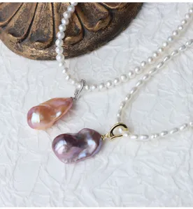 Primo piano del ciondolo di perla barocca d'acqua dolce, design coda di pesce colorata e argento.