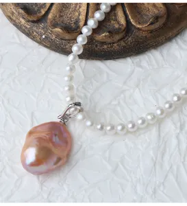 Dettaglio in primo piano della collana con pendente in perla barocca con chiusura in argento.
