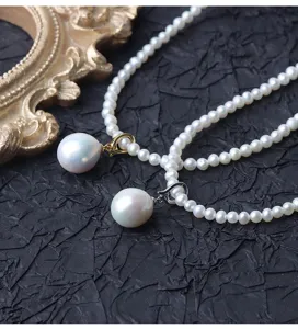 Primo piano dettagliato di squisita collana di perle con grande ciondolo di perla barocca.