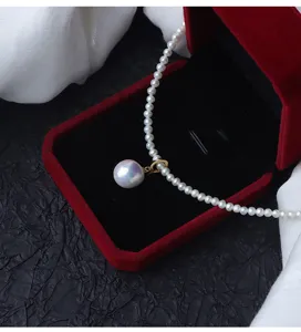 Primo piano dettaglio del ciondolo con collana di perla barocca e chiusura universale in argento.