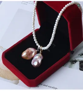 Collana con pendente in perla d'acqua dolce barocca a coda di pesce in velluto rosso.