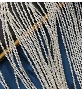 Close-up detail of multiple small white freshwater pearl strands hanging down elegantly.